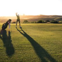 2 person walking on green grass field during daytime